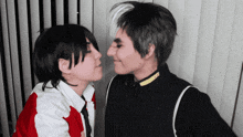two people kissing with one wearing a black jacket