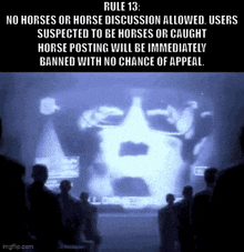 a group of people standing in front of a screen that says " rule 13 "