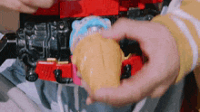 a person is holding an ice cream cone in front of a toy .