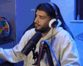 a man wearing headphones is sitting in front of a microphone with the name 3mhashley visible in the corner