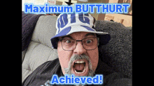 a man wearing a hat that says maximum butthurt achieved on it