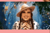 a woman wearing a cowboy hat and a leopard print shirt is smiling