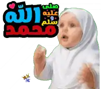 a baby wearing a white hijab is standing in front of a sign that says ' muhammad '