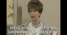 a woman is sitting in front of a door and talking to a man .
