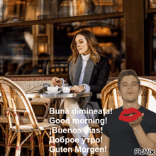 a woman is sitting at a table with a cup of coffee and a man is blowing a kiss