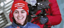 a woman wearing a red hat with the word viessmann on it smiles