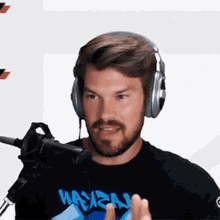 a man wearing headphones is talking into a microphone while wearing a hawaii shirt