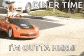 a man is driving a toy car down the street .