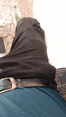 a person wearing a black belt with a silver buckle