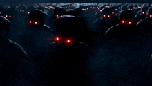 a large group of people with red eyes are walking in the dark