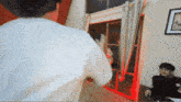 a man in a white shirt is standing in a room