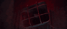 a close up of a red light on a wooden floor in a dark room .