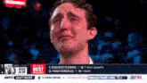 a man is crying while watching a basketball game