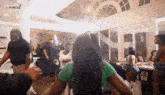 a group of people are dancing in a room with the words now that 's tv on the bottom right