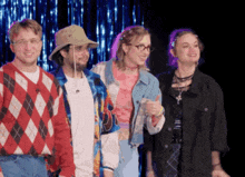 a group of people are standing next to each other and one of them is wearing a hat