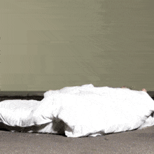 a person laying on a bed with a white sheet