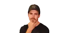 a man wearing a hat with the letter t on it is clapping his hands