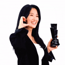 a woman in a black jacket is holding a black trophy that says ' aa ' on it