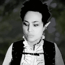 a black and white photo of a woman in a ruffled shirt