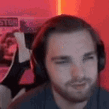 a man with a beard wearing headphones is sitting in a chair .
