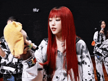 a woman with red hair is holding a yellow hat in her hands