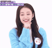 a woman wearing a blue sweater has a name tag that says ' lee ah ' on it