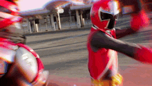a man in a red superhero costume stands in front of a bus