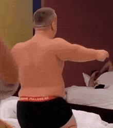 a shirtless man wearing black underwear with the word pullbear on the waist