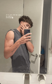 a man taking a picture of himself in a bathroom mirror with the words it 's you and me