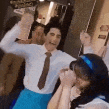 a man in a suit and tie is dancing with a woman in a headband .