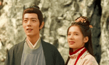a man and a woman are standing next to each other and looking up at something .