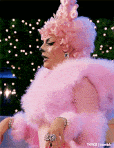 a drag queen is wearing a pink wig and a fur coat