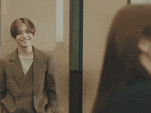 a man in a brown suit is smiling and looking at a woman