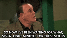 a man in a suit is talking about waiting for something