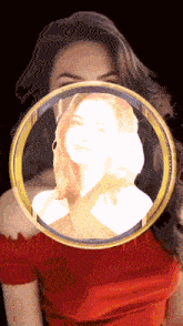 a woman in a red shirt is behind a gold circle