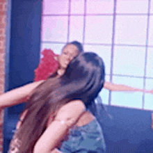 a woman with long hair is dancing in front of a window in a room .