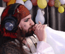 a man with a beard wearing headphones and a bandana with a cross on it