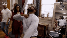 a man in a white shirt is dancing in a hair salon .