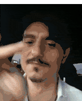 a man with a beard and mustache is pointing his finger at the camera