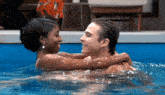a man and woman are hugging in a pool