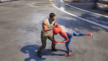 a man in a white tank top is fighting a spider man