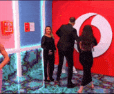 a woman in a black dress is standing in front of a vodafone sign