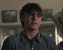 a young man wearing a striped shirt looks at something