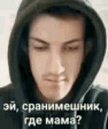 a close up of a man wearing a hooded jacket with a foreign language on it .