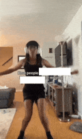 a woman wearing headphones is dancing in a living room with the words " how people be moving " above her