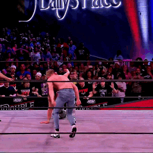 a wrestler in a ring with a crowd behind him and a sign that says daily race