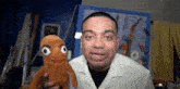 a man in a white shirt holds a stuffed animal with big eyes