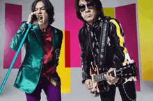 a man in a colorful suit is singing into a microphone while another man is playing a guitar .