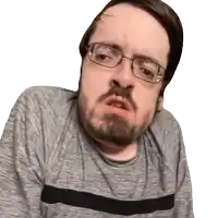 a man with glasses and a beard looks at the camera