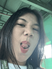 a woman is sticking her tongue out and wearing a camera strap that says " juice "